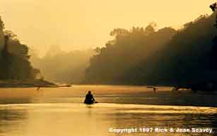 Yagua indian canoeing into Peru sunset.