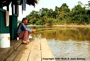 Rick Seavey and Adriana Arevalo fishing off raft at Madre Selva Biological Station, Peru.